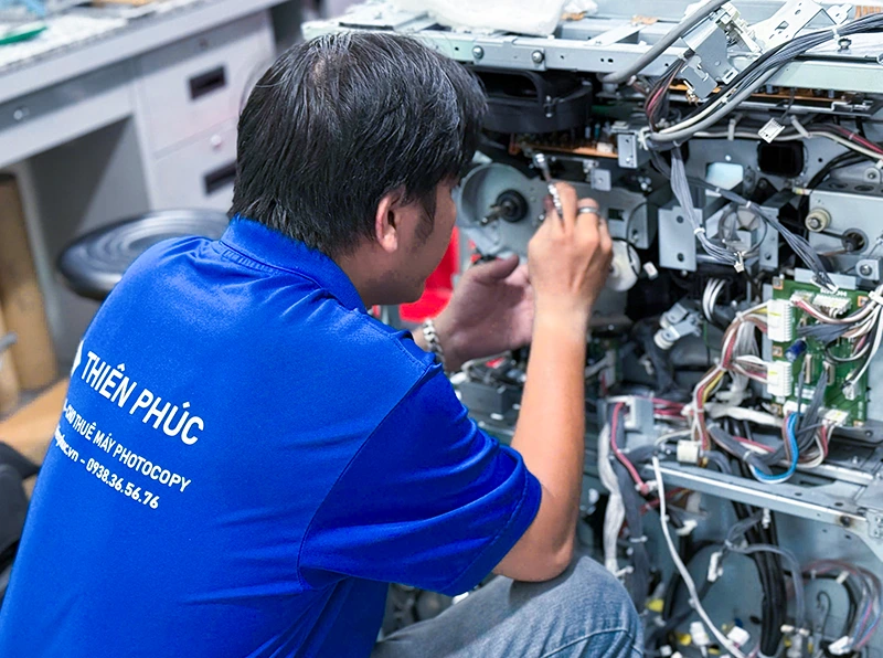 Kỹ thuật viên Thiên Phúc đang sửa máy photocopy